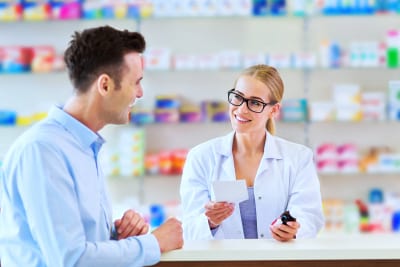 Pharmacist and client at pharmacy, smiling